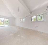 Spacious interior of a family house with large windows and a neutral design.