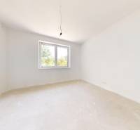 An empty room with a window and a light bulb in a family house, ready for renovations.