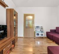 In the 3-room apartment, there is a television, wooden furniture, and a purple sofa.
