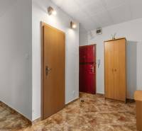 A hallway in a 3-room apartment with a coat rack, a wardrobe, and dark tiles.