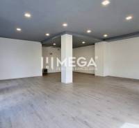Bright office with flooring and columns, available for rent.