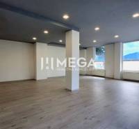 A spacious office interior with wooden flooring and ceiling lighting.