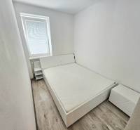 Bedroom with a bed and a nightstand in a 2-room apartment.