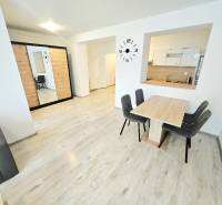 Living room with a dining table in a two-room apartment, bright interior and wooden floor.