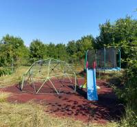 Záhrada rodinného domu v Borši na Hlavnej ulici s hojdačkou a trampolínou.