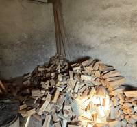 Wood stored in a room with simple walls and work tools.