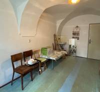 Interior of a 1-room apartment with simple furniture, a sink, and a curved ceiling.