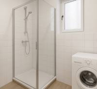 Bathroom with a washing machine, shower, and white tiles in a studio apartment.