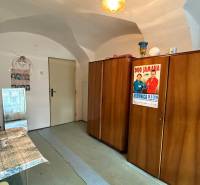 Interior of a studio apartment with a wardrobe, sink, and a poster on the wall.