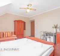 A room in hotels and guesthouses with wooden furniture, a television, and a sofa.