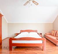 A bright room in hotels and guesthouses with wooden furniture and a sofa.