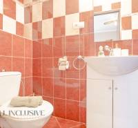 Bathrooms in hotels and guesthouses with red tiles, a sink, a toilet, and a mirror.