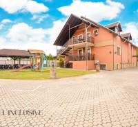Exterior of hotels and guesthouses in Veľký Meder with a children's playground and a gazebo.