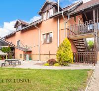 Exterior of the building with wooden terraces, garden, and playground in Veľký Meder, hotels and guesthouses.