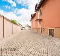 A flat path lined with an orange building in the premises of hotels and guesthouses in Veľký Meder.