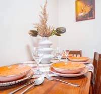 Table with place settings, ceramic plates, glasses, and decorations in hotels and guesthouses.