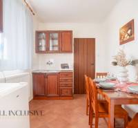 Kitchen in hotels and guesthouses with wooden cabinets, a table, and decoration on the table.