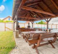 Garden in Hotels and Guesthouses in Veľký Meder with a gazebo and wooden seating.