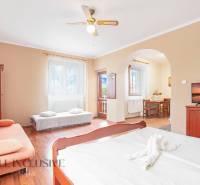 A room in a hotel and guesthouse with a bed, sofa, and dining seating.
