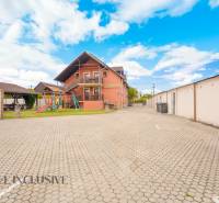 Exterior of hotels and guesthouses in Veľký Meder with a children's playground and parking lot.
