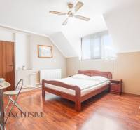 Hotel rooms and guesthouses with wooden beds, white bed linens, and a table with dishes.