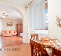 Dining and living area in a guesthouse with wooden furniture and decorations.