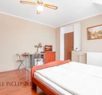 A bright hotel room with a double bed, decorations, and a dining area.