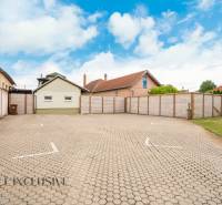 Parking at Hotels and Guesthouses in Veľký Meder with surrounding buildings and sky.