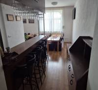 Bar counter and dining table in a studio apartment with wooden flooring.