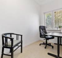 Offices with an office chair, desk, and a black armchair by the window.