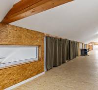 Attic offices with wooden elements and curtains, spacious interior, modern work environment.