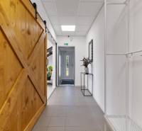 Hallway with gray tiles, wooden doors, and decoration in Offices.