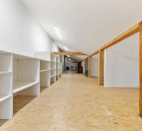 A long room with white shelves and wooden beams in the office.