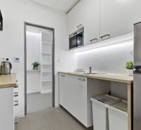 A kitchen in offices with white cabinets, a microwave, and a refrigerator.