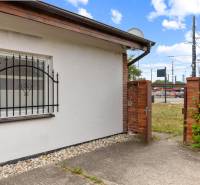 A building with a window and a grille, a brick fence, a view of the area in Bratislava on Vajnorská Street.