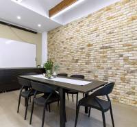 Offices with a brick wall, black table, chairs, and plants.