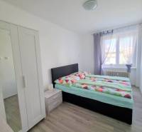 Bedroom in a 2-room apartment with a comfortable bed, wardrobe, and natural light.
