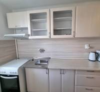 Kitchen in a 2-room apartment with a white unit, oven, and sink.
