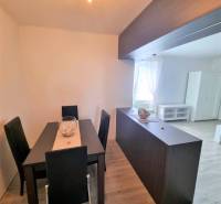 Dining area in a 2-room apartment with a black table and chairs, bright interior.