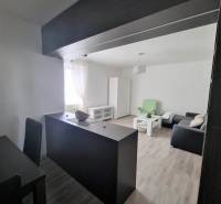 Interior of a 2-room apartment with a sofa, table, and dining area.