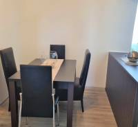 Dining area with a table and four chairs in a 2-room apartment.