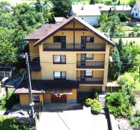 A family house in Vyšná Myšľa surrounded by greenery and neighboring buildings.