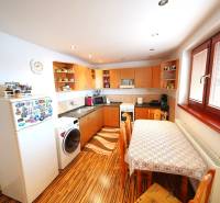 A kitchen in a family house with a wooden cabinet and a dining table.