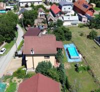 A family house in Vyšná Myšľa with a garden and a swimming pool, surrounding houses and a lane.