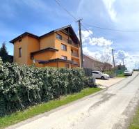 A family house in Vyšná Myšľa surrounded by a hedge on a quiet street.