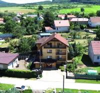 A family house in Vyšná Myšľa surrounded by gardens and neighboring houses in a picturesque setting.