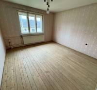 A room with a wooden floor in a 3-room apartment, Lietavská Lúčka, wallpapered walls.