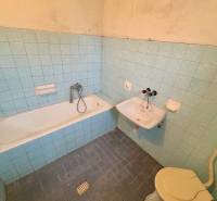 A classic bathroom with blue tiles, a bathtub, and a sink in a 3-room apartment.