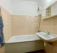 A bathroom with a bathtub, sink, and mirror cabinet in a 3-room apartment.