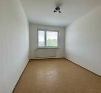 An empty room with a window and a radiator in a 3-room apartment.